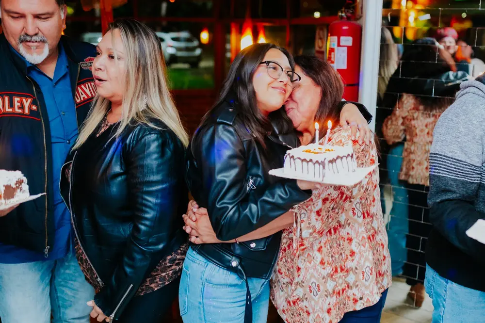 Abrazo de cumpleaños junto a la torta